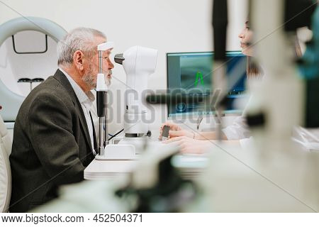 Ophthalmologist Examination Of Elderly Man On Corneo Topographer.modern Clinic