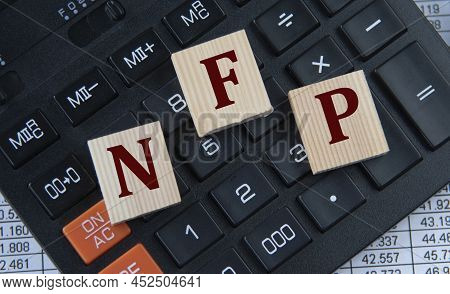 Nfp (non-farm Payrolls) - Acronym On Wooden Cubes On The Background Of A Calculator. Business Concep