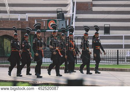 Wagah Border, Pakistan - July 22, 2021: Brave Pakistan Soldiers In Bright Military Uniform Marching 