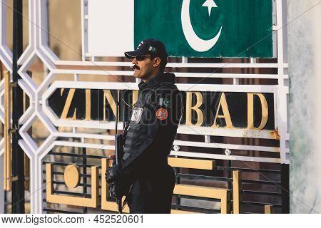 Wagah Border, Pakistan - July 21, 2022: Brave Pakistan Soldier In Sunglasses With The Gun Near The M