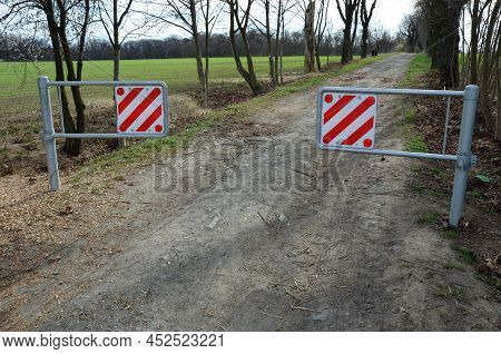 A Barrier To Dirt Road Consisting Of Two Barriers That Allow Cyclists And Pedestrians To Enter. Cars