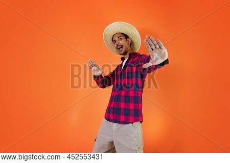 Black Man With Junina Party Outfit  Isolated On Orange Background.