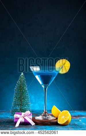 Vertical View Of Alchocol Cocktail In A Glass Goblet Served With Lemon Slice And Gift Box Christmas 