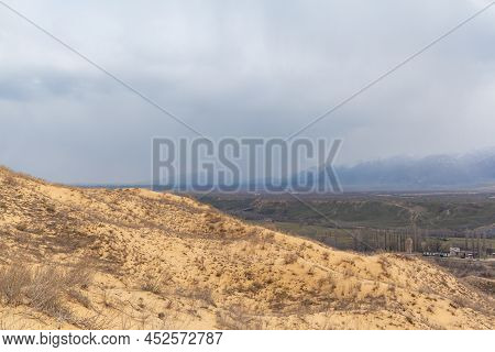 Sarykum Dune. Dagestan, Russia. A Unique Sandy Mountain In The Caucasus On A Cloudy Day. Grass Grows