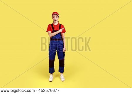 Full Length Portrait Of Excited Amazed Handy Woman Standing And Pointing Finger Away, Showing Copy S