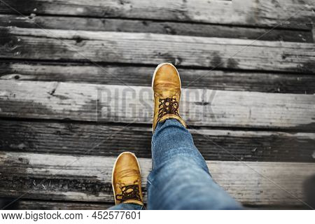 Steps In Yellow Shoes And Blue Jeans Is Walking Up The Gray Steps. Support For Ukraine.