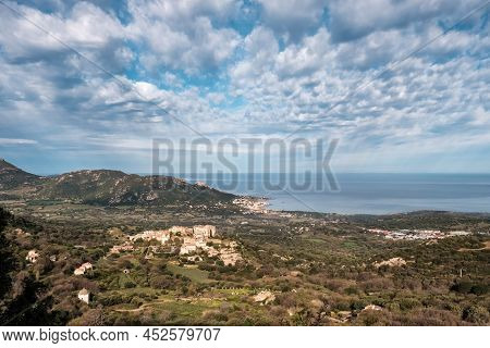 Hilltop Village Of Pigna In The Balagne Region Of Corsica With Mediterranean Sea In The Distance