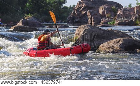 A Man Rowing Inflatable Packraft On Whitewater Of Mountain River. Concept: Summer Extreme Water Spor