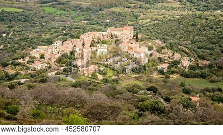 Hilltop Village Of Pigna In The Balagne Region Of Corsica With Mediterranean Sea In The Distance