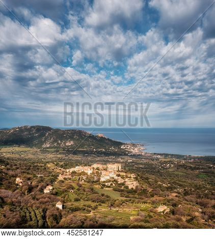 Hilltop Village Of Pigna In The Balagne Region Of Corsica With Mediterranean Sea In The Distance