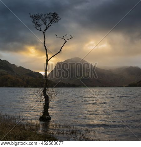 Stunning Autumn Sunrise Landscape Image Of Buttermere In Lake District With Dramatic Stormy Sky
