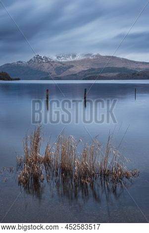 Stunning Landscape Image Of Loch Lomond And Snowcapped Mountain Range In Distance Viewed From Small 