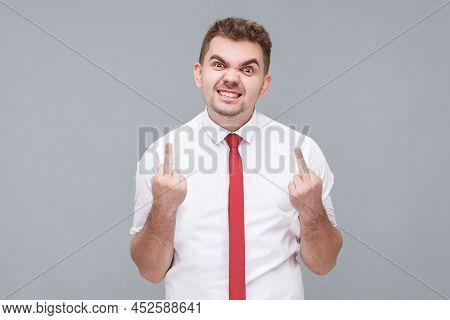 Portrait Of Young Angry Man In White Shirt And Tie Standing With Middle Finger And Angry Face Lookin