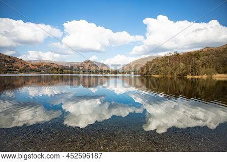 Landscape Reflections Of Clouds And Blue Sky In Grasmere Lake In The Lake District National Park