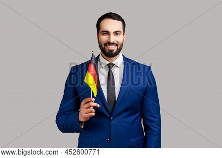Delighted Businessman Holding Germany Flag, Celebrating Day Of Germany - 3th October, Expressing Pos
