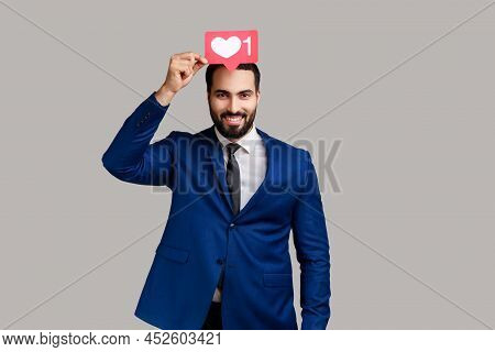 Positive Man Holding Heart Like Icon Of Social Media Above Head, Notification Button To Follow, Subs