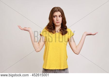 I Dont Know, Who Cares. Portrait Of Confused Clueless Attractive Teenager Girl In Yellow T-shirt Shr