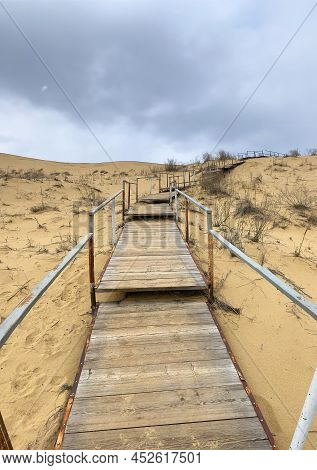 The Staircase Rises To A Sandy Dune. Climbing To The Top In The Desert. Sarykum Dune. Dagestan, Russ