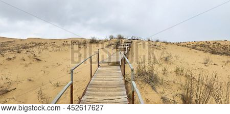 The Staircase Rises To A Sandy Dune. Climbing To The Top In The Desert. Sarykum Dune. Dagestan, Russ
