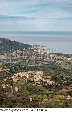 Hilltop Village Of Pigna In The Balagne Region Of Corsica With Mediterranean Sea In The Distance