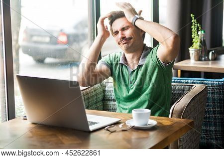Portrait Of Desperate Businessman Wearing Green T-shirt, Feeling Sorry And Blaming Himself For The M