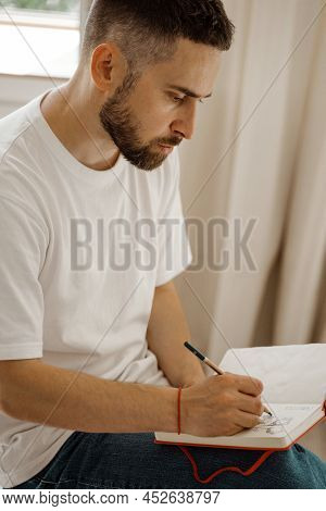 The Artist Sits On A Chair And Makes A Sketch. Portrait Of A Man Making A Pencil Sketch. Creative Wo