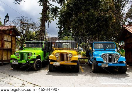 Salento, Colombia - July 2021. Traditional Jeeps Willy Parked At The Main Square Of The Beautiful Sm