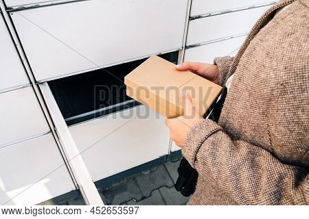 Automated Locker. Parcel Courier Box In Woman Hands At Post Delivery Automat Terminal. Courier Puts 