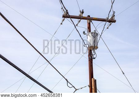 Electricity Pole With High Voltage Sign And Power Lines