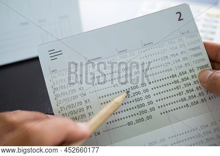 Finger Holding Pencil Point Data Numeric Withdrawal Amount On Accounting Bank Book. Plan Investment 