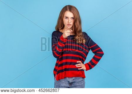 Hey You, Be Careful. Portrait Of Young Woman Wearing Striped Casual Style Sweater Seriously Pointing