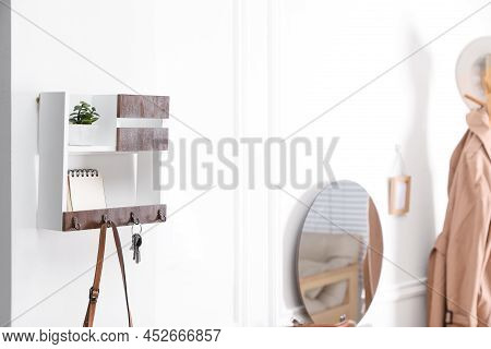 Wooden Key Holder On White Wall In Hallway