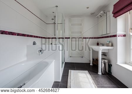 Fen Drayton, England - June 7 2018: Simple Modern Tiled Bathroom With White Ceramic Tiled Walls