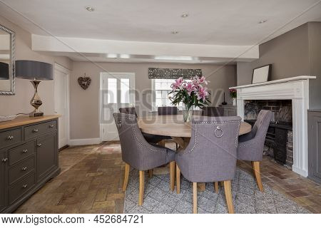 Fen Drayton, England - June 7 2018: Furnished Dining Room With Exposed Brick Floor And Fireplace