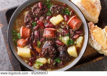 Stone Soup Of Red Beans, Potatoes, Chorizo, Black Pudding Close-up In A Bowl On A Wooden Tray. Horiz