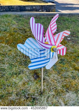 Colorful Pinwheel With Houses In The Background