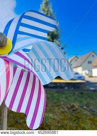 Colorful Pinwheel With Houses In The Background