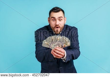 Greedy Businessman Wearing Official Style Suit Holding Lot Of Money And Expressing Excitement, Showi