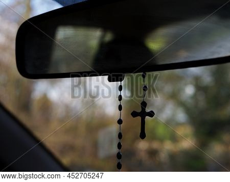 Rosary Beads Crucifix Hangs On Bokeh Background