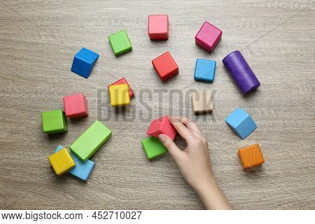 Aba Therapist With Colorful Building Blocks At Wooden Table, Top View