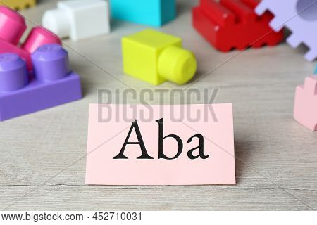 Paper Sheet With Abbreviation Aba (applied Behavior Analysis) And Colorful Wooden Blocks On White Ta