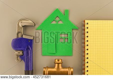 Diy, Renovation Or New Build Home Concept With Wrench, Copper Plumbing Joint And Notebook Alongside 