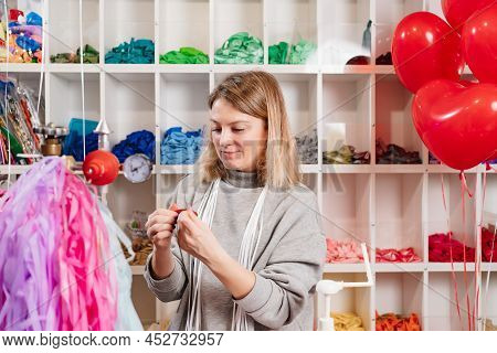 Aerodesigner. A Woman Treats The Red Balloon With Gel Before Inflating.