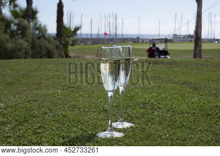 Celebration Of Championship With Glasses Of Champagne Bubbles Wine On Green Lawn Of Golf Club