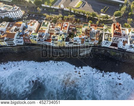 Aerial View On Colorful Houses And Black Lava Rocks In Small Village Punta Brava Near Puerto De La C