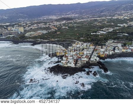 Aerial View On Colorful Houses And Black Lava Rocks In Small Village Punta Brava Near Puerto De La C