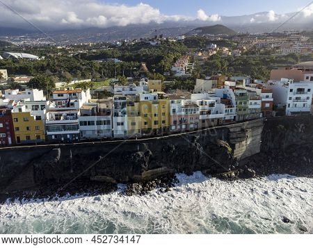 Aerial View On Colorful Houses And Black Lava Rocks In Small Village Punta Brava Near Puerto De La C