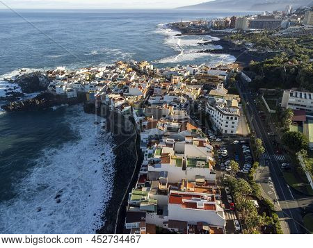 Aerial View On Colorful Houses And Black Lava Rocks In Small Village Punta Brava Near Puerto De La C