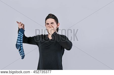 A Man With A Sock In His Hand Covering His Nose, A Guy With A Stinky Sock In His Hand, Smelly Socks