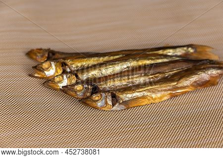 Smoked Capelin Against A Beige Background. Five Ready-to-eat Little Fish. Seafood.